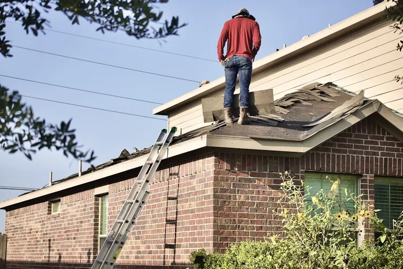 Professional roofer working on a residential roof in Ladds